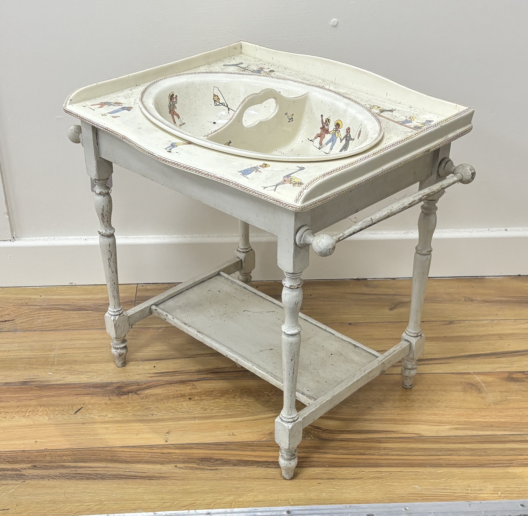 A French Sarreguemines pottery child's basin decorated with nursery scenes and matching wash stand, 51 x 37 x 48cm